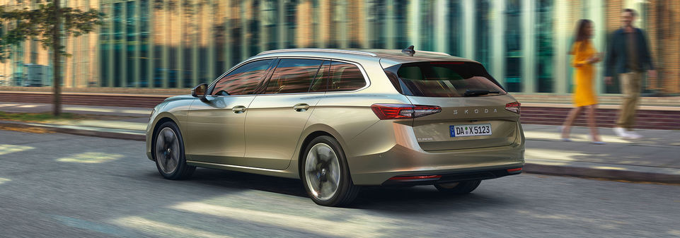 Ein Škoda Superb Combi in Beige fährt durch eine Straße.